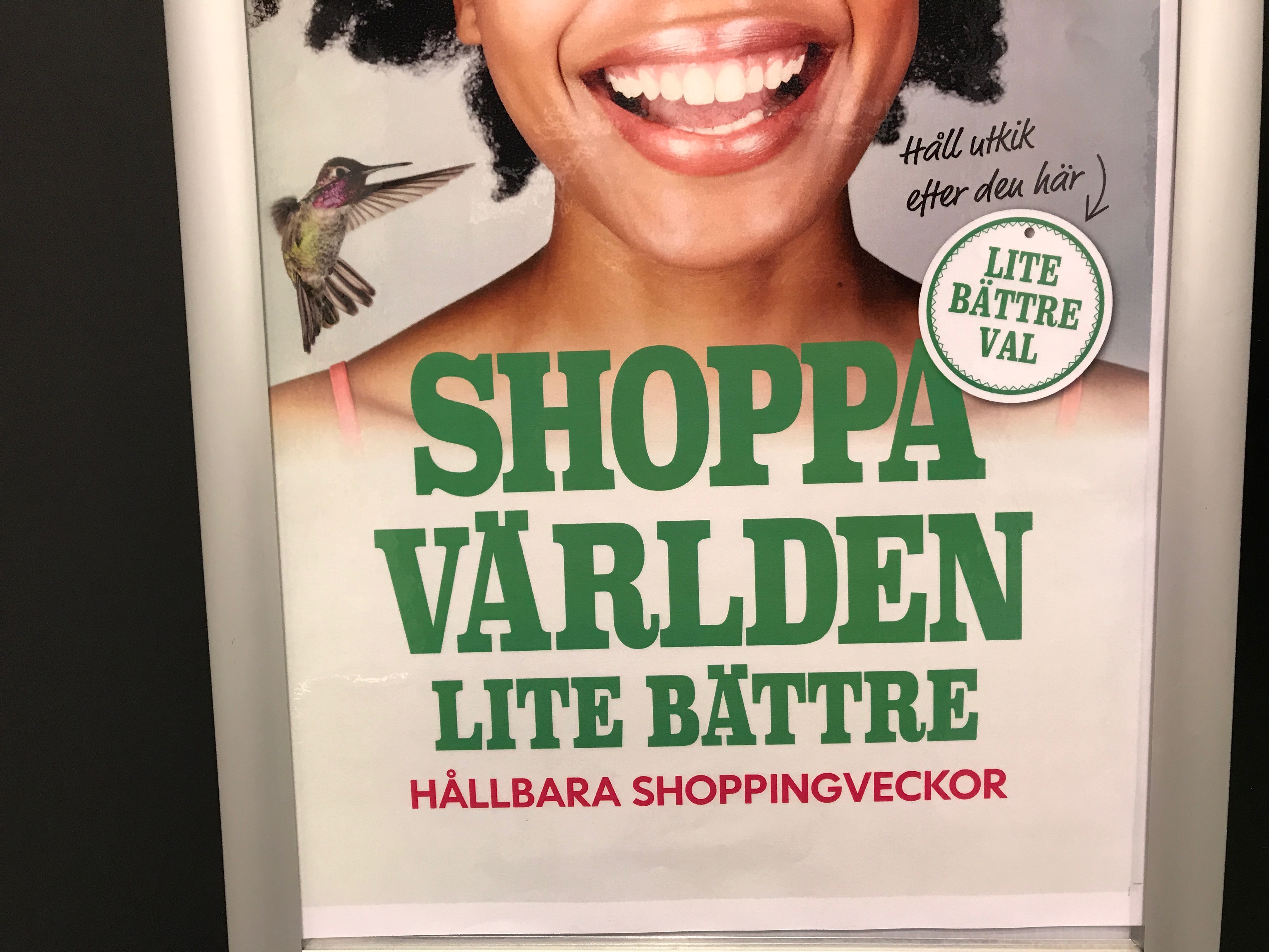 Reklamaffisch med texten "Shoppa världen lite bättre"